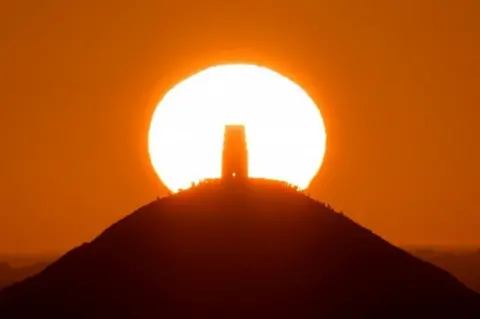 Reuters People standing around Glastonbury Tor in Glastonbury, as the sun rises.