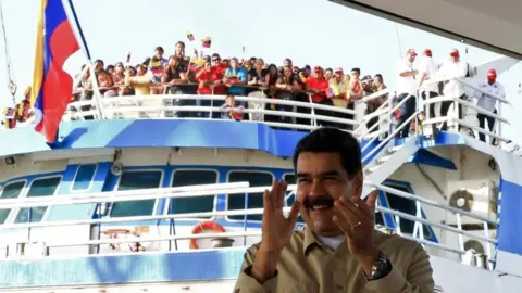 AFP Handout photo released by the presidential press office showing President Nicolas Maduro applauding in the port of La Guaira, Venezuela on 2 August 2019