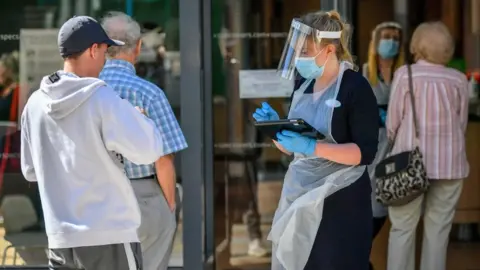 Ben Birchall PA Wire Queue outside an opticians in Merthyr Tydfil