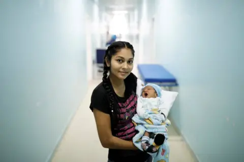 Nacho Doce/REUTERS Jasmilfer, 23, a Venezuelan from Monagas state, holds her five-day-old baby Arjunea at a maternity hospital in Boa Vista, Roraima state, Brazil, 21 August 2018