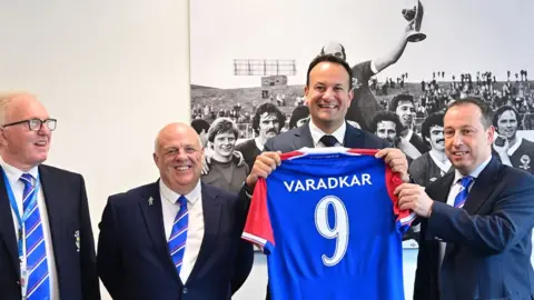 Pacemaker Varadkar holds up a Lindfield Jersey with his name on it.