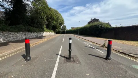 Bollards at the top of Dryden Road and a cycle lane to the right
