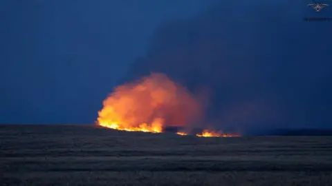 A night-time image of a large fire on Salisbury Plain against an inky blue sky in Wiltshire. 