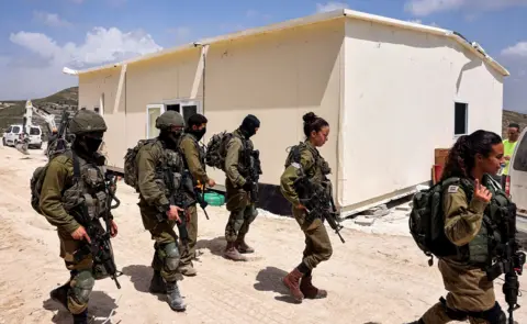 AFP Israeli soldiers patrol outside the construction of a portable building at the Homesh site in the West Bank on 29 May 2023.