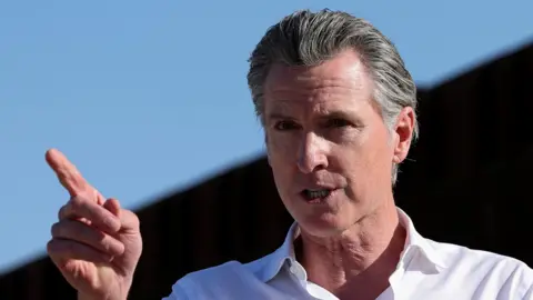 Gavin Newsrom with a stern expression pointing his finger