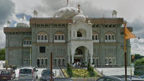A Google Maps image of the Gurdwara in Gravesend, a beautiful grey and white carved building with domed turrets and flags waving outside/