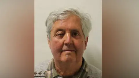 Brian Darby in police custody shot. An elderly man with white hair.