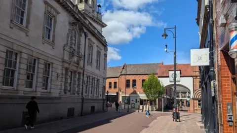 Pedestrianised street in Leicester with blue sky above