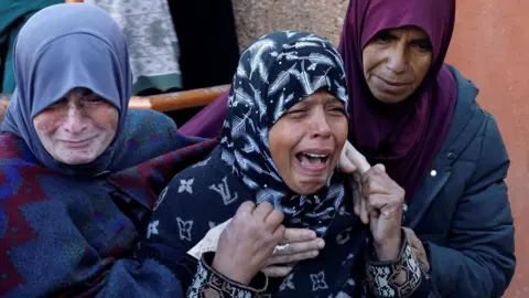 Reuters Women mourn during a funeral for Palestinians killed in overnight Israeli strikes in the Khan Younis area, southern Gaza (8 January 2025)