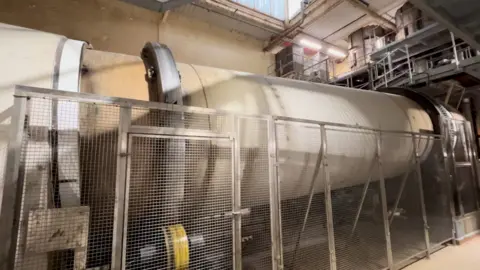 A large rotating cylinder machine inside a sugar factory