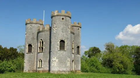 Getty Images Blaise Castle in Bristol under a clear sunny sky with lush green grass and surrounding trees