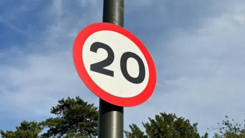 Getty Images A sign for a 20mph speed limit against a blue sky.