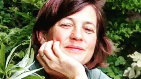 Tom Curtis. Primer plano de la Dra. Tonya Lander, afuera, entre la vegetación. Sonríe.