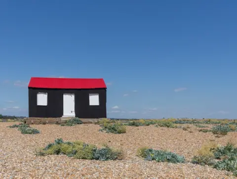 Quintin Lake Beach hut with red roof, Rye Harbour, Sussex.