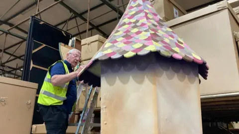 BBC Man decorating a panto house