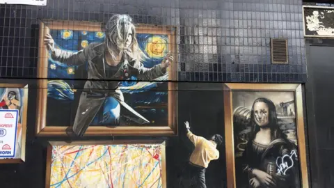 A close up of murals on the facade