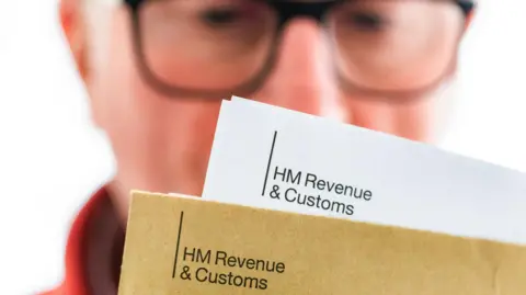 Getty Images A man looking at a letter from HMRC