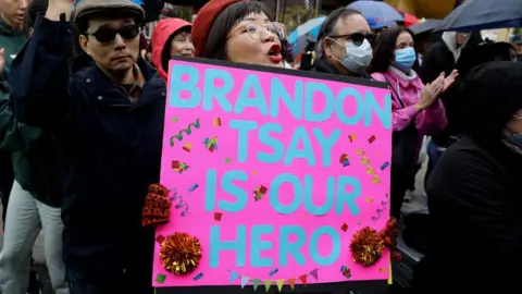 Gary Coronado//Los Angeles Times via Getty Images A supporter cheers at a Lunar New Year celebration where Brandon Tsay was honoured.