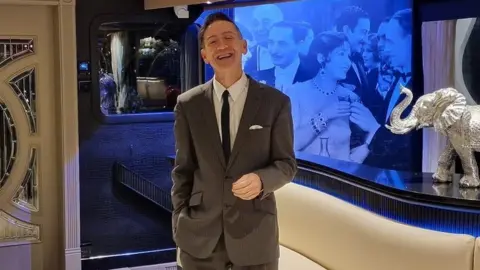 Facebook Thomas Flight smiling at the camera while wearing a suit