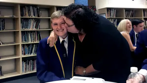 BBC A pupil from Greenfaulds High in Cumbernauld gets a kiss from his mum as he receives his results