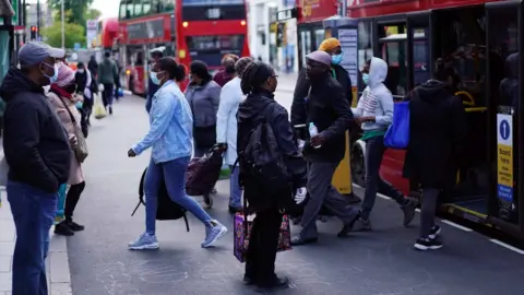 Reuters People waiting for a bus