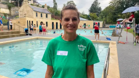 A woman wearing a green t-shirt by the pool