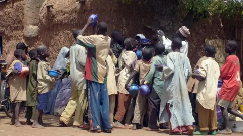 AFP A crowd of child beggars struggle for alms from a man in northern Nigeria's Kano city (file photo)