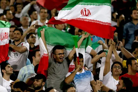 AFP/Getty Images Supporters of Iran cheer for their team during the FIFA World Cup 2018 qualification football between Syria and Iran at the Azadi Stadium in Tehran on 5 September 2017