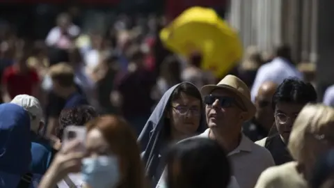 Getty Images Street scene of people wearing sun protection