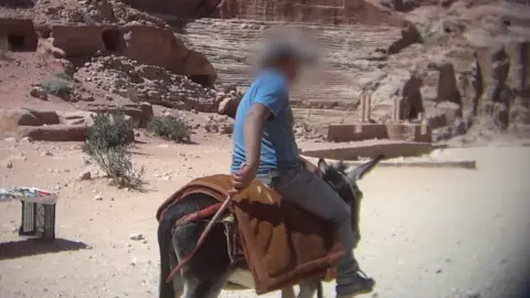 Peta Asia A man rides a donkey at Petra