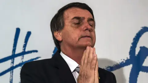 Getty Images Brazilian deputy Jair Bolsonaro gestures during a press conference he called to announce his intention to run for the Brazilian presidency in the October 2018 presidential election, at a hotel in Rio de Janeiro on August 10, 2017.