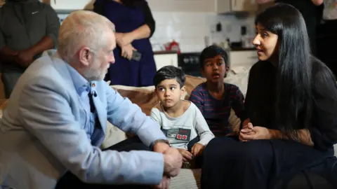 PA Media Jeremy Corbyn speaks to a mother at Clyde House in Putney