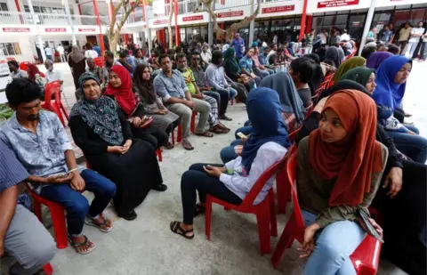 Reuters People sit in line as they wait to cast their votes at a polling station during the presidential election in Male, Maldives