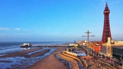 PA Media The sun sets over Blackpool beach