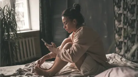 Getty Images woman looking at phone