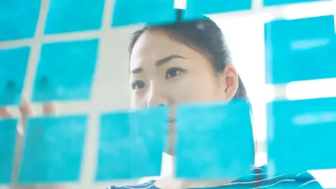 Getty Images Woman peering at data