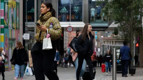 Getty Images Girl carrying phone on High Street