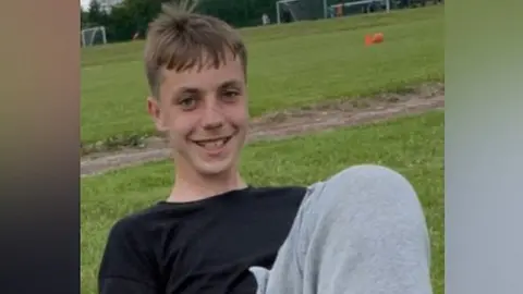 Family handout Tomasz smiles at the camera