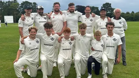 Submitted Group of men and boys wearing cricket whites 