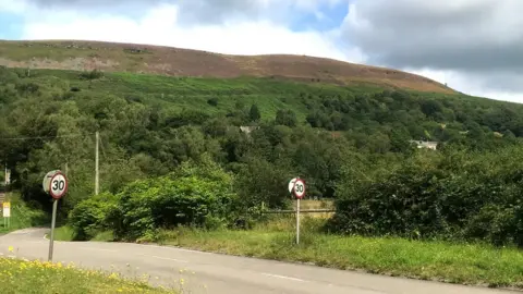 The "two tone" landscape above Ystalyfera with hard sandstone at the top and vegetation growing on the softer layers