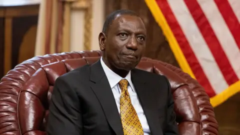 EPA President Ruto, sat down and looking away from the camera