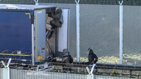Getty Images Migrants breaking into lorry near Calais