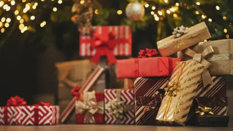 Presents wrapped up by a Christmas tree