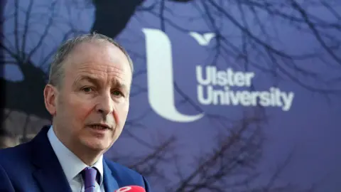 PA Media Micheál Martin with Ulster University logo in background