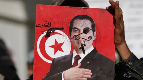 Christopher Furlong/Getty Images A 2011 placard condemning Tunisia's ousted leader Zine al-Abidine Ben Ali