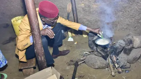 DIDMUS BARASA MP Didmus Barasa makes tea at a fireplace