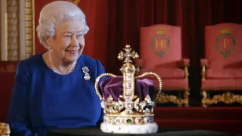 BBC Queen Elizabeth II sitting next to the Imperial State Crown