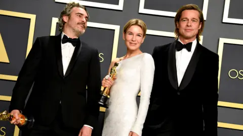 PA Media Joaquin Phoenix, Renee Zellweger and Brad Pitt with their statuettes