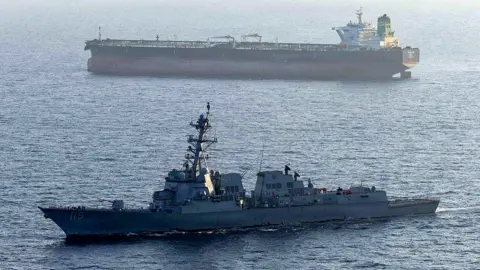 A US military ship is seen in the foreground in the Arabian Sea in April, while another ship is seen in the background.