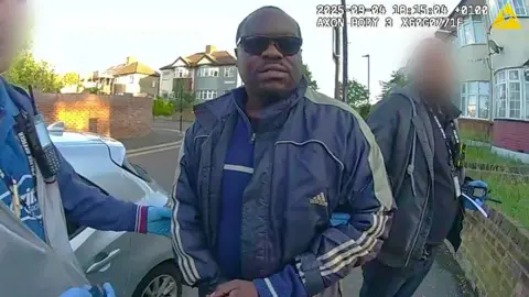 Still of Met Police detaining Simon Levy on a street